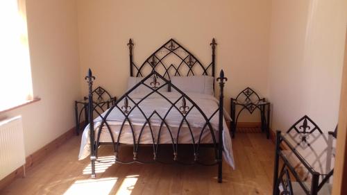 LoughanureTeach Nellie Cottage的一间卧室,在房间内配有一张铁床