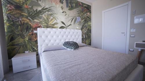 切萨雷奥港Hotel Royal - Beauty & Spa的卧室配有白色床和植物壁纸