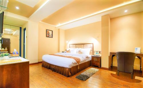 马图拉奥德拉神圣酒店的一间卧室配有一张床、一张桌子和一把椅子