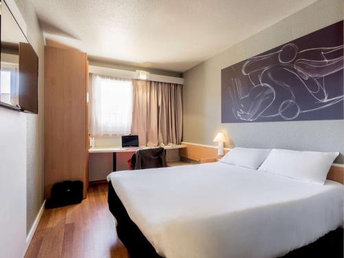 格拉纳达宜必思格拉纳达酒店的酒店客房设有一张白色大床和一张书桌