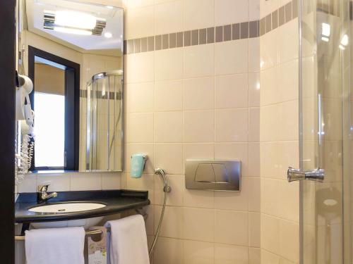 科威特ibis Sharq的浴室配有盥洗盆和带镜子的淋浴