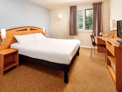 林肯宜必思林肯酒店的酒店客房设有一张大床和一张书桌。