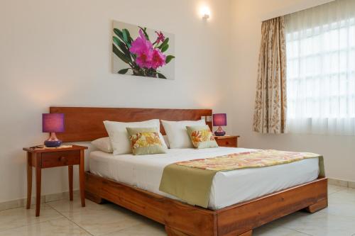 塔卡马卡开普登别墅酒店的一间卧室配有一张带两张桌子和一扇窗户的床。