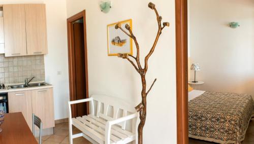 圣凯撒利亚温泉Il Corbezzolo的一间设有桌子、椅子和树的房间
