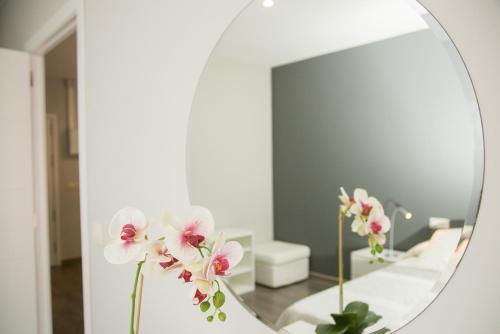 赫尔特Apartamentos Dacris的浴室内带鲜花的镜子
