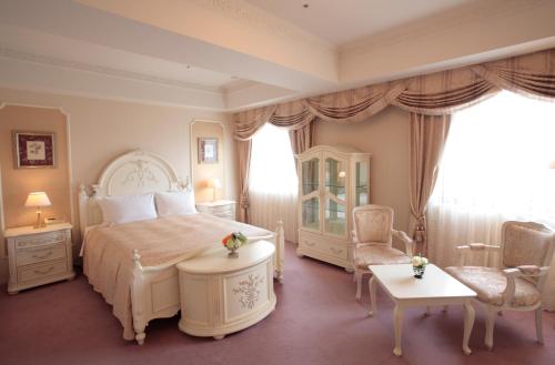 水户Hotel Lake View Mito的卧室配有一张床和一张桌子及椅子