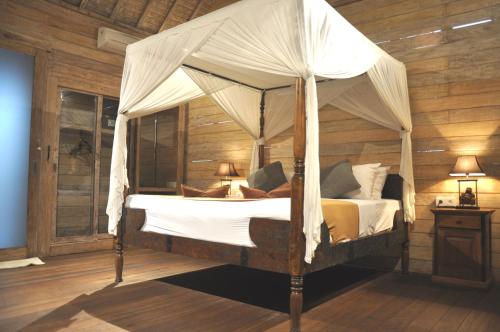 坎古库布迪尤玛巴厘岛别墅的一张带天蓬的床