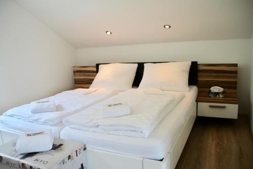 WeiteneggHaus am Donausee (House at the Danube Lake Beach)的一间卧室配有两张带白色床单的床
