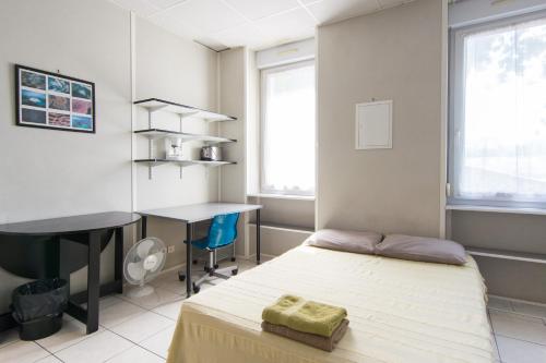 马赛及时行乐公寓式酒店的一间卧室配有一张床、一张桌子和一张桌子