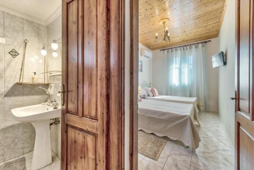 Agios LeonSempreviva的一间带水槽的浴室和一张位于客房内的床