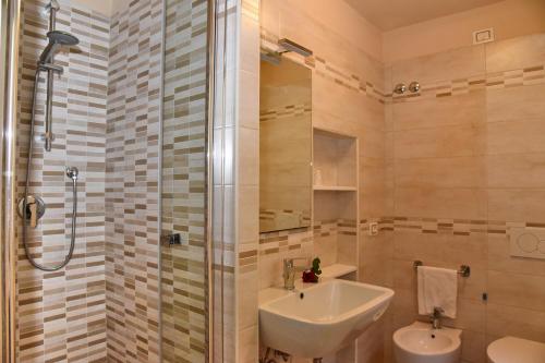 丘西Albergo La Rosetta的一间带水槽和淋浴的浴室