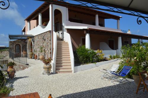 利帕里B&B Villa Maristella的庭院中设有楼梯和椅子的房子