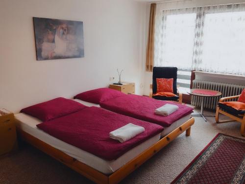 海姆巴赫Eifelhof Weina的一间卧室配有一张带红色床单的大床