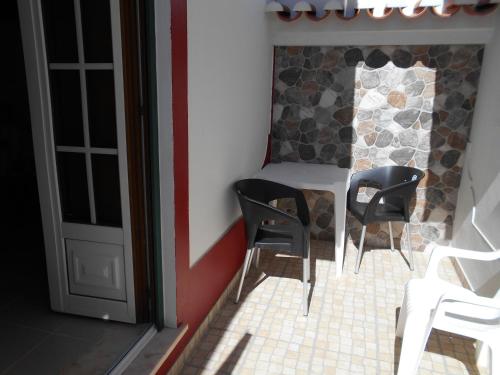 赞布热拉-杜马尔Sol Dourado的一间设有两张黑椅子和一张桌子的房间