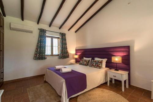 赞布热拉-杜马尔蒙大格夏酒店的一间卧室配有一张大床和紫色床头板