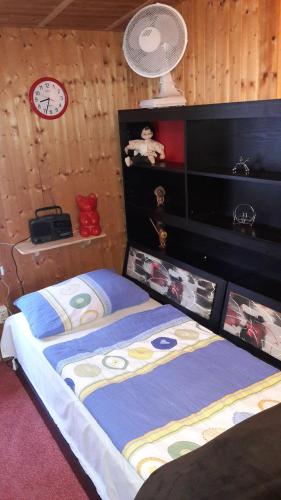 菲尔斯滕贝格Mobile-Home的卧室配有一张床,墙上挂着一个钟
