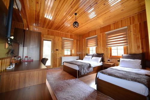乌宗Goblec Hotel & Bungalow的木制客房内的一间卧室配有两张床