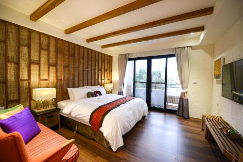 小琉球岛泰美风情旅店的一间卧室设有一张床和一个大窗户