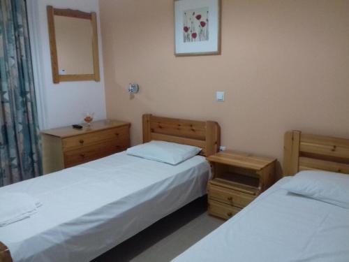 拉夫蒂港Nikolaki Rooms的一间卧室配有两张床、镜子和两张桌子