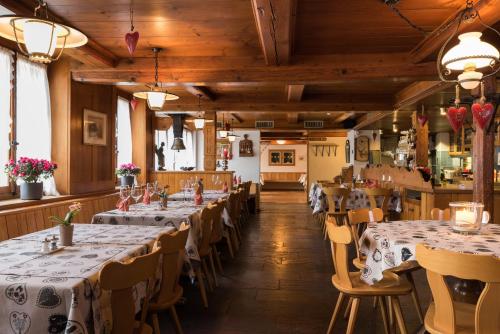 因特拉肯Hotel Restaurant Hirschen的餐厅的一排桌子,有白色桌布