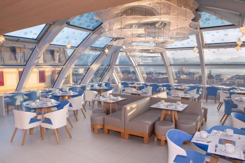 洛桑Agora Swiss Night by Fassbind的餐厅设有桌椅和大窗户。