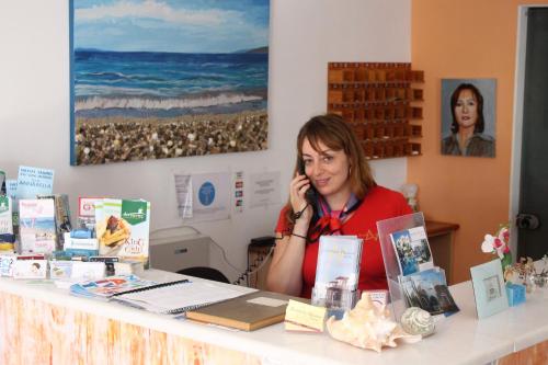 圣安娜纳克索斯安妮塔乡村酒店的坐在一张桌子旁的一位女士,在手机上讲话