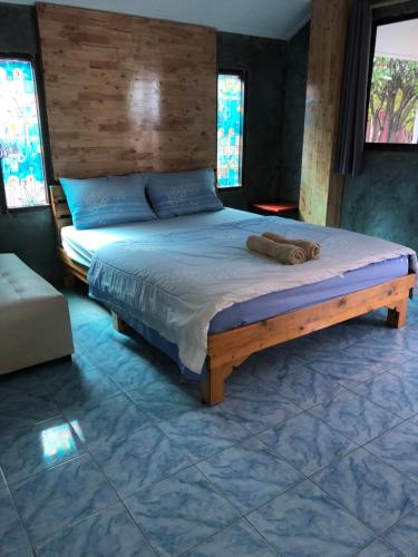 格兰岛Poopreaw Koh Larn的一间卧室配有一张大床和木制床头板