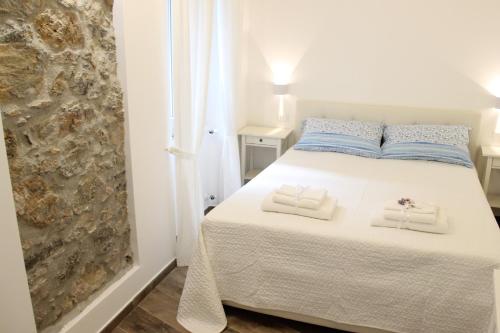 日科德尔格尔福迪艾斯Casa Maiò的卧室配有白色的床和2条毛巾