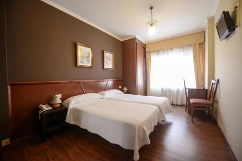 卡拉米尼亚尔镇霍斯佩达科斯维拉旅馆的酒店客房设有两张床和窗户。