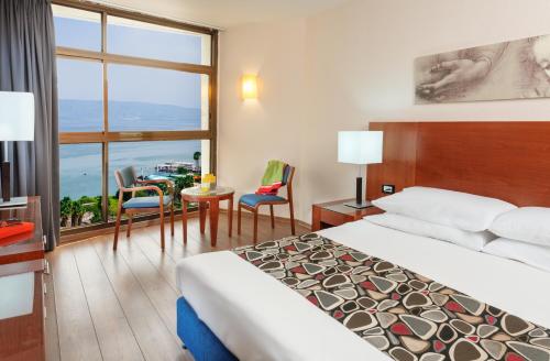 提比里亚太巴列莱昂纳多酒店的酒店客房,配有一张床和一张桌子及椅子