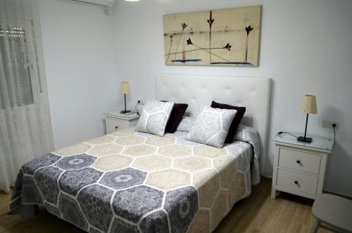 福恩吉罗拉Apartamento Cervantes的一间卧室配有床和2个床头柜