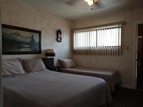 Thayne瑞士山汽车旅馆的一间卧室设有两张床和窗户。