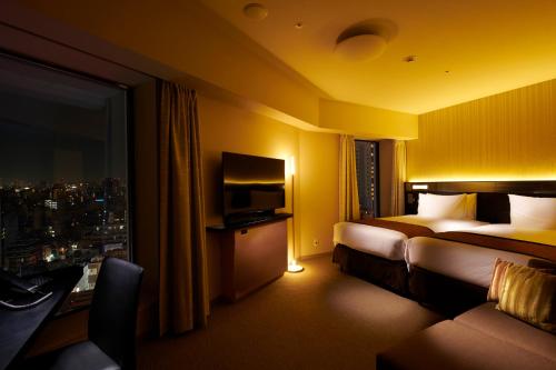 东京里士满浅草国际酒店的酒店客房设有两张床和电视。