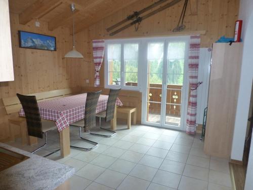 格林德尔瓦尔德Chalet Verbrunnenhaus Grindelwald的一间带桌椅和窗户的用餐室