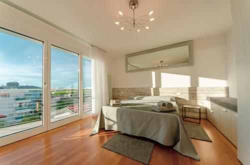 利尼亚诺萨比亚多罗Soleis Sea View Spa Apartment的一间卧室设有一张床和一个大窗户