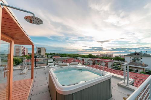 利尼亚诺萨比亚多罗Soleis Sea View Spa Apartment的大楼阳台上的热水浴池