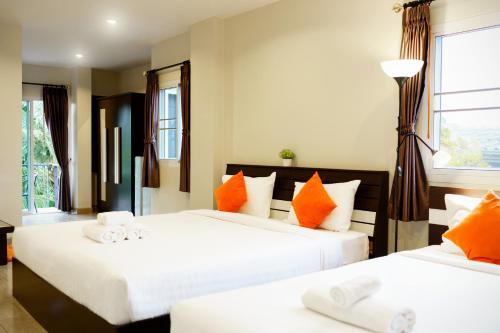 素叻我的梦想公寓的一间卧室配有两张带橙色和白色枕头的床