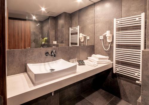 卢布尔雅那阿特里尔酒店的一间带水槽和镜子的浴室