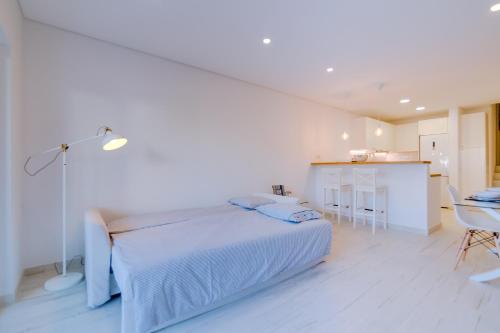 韦尔都勒博Villa V1 Vale do Lobo Beach的一间白色卧室,配有床和厨房