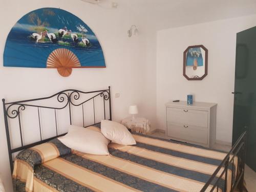 卡帕尔比奥La Casetta Blu的卧室配有一张床,墙上挂有绘画作品