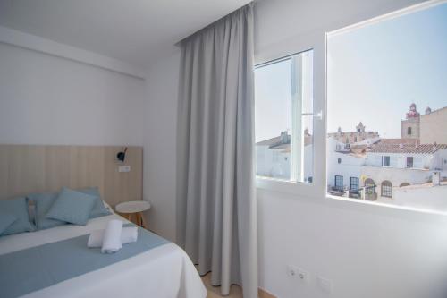 休达德亚Sagitario Petit Ciutadella的一间卧室设有一张床和一个大窗户
