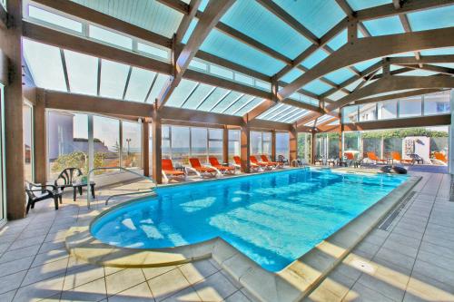 滨海拉特朗什沙丘酒店的大型客房的游泳池,设有大型玻璃天花板