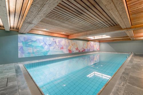 圣莫里茨赛瓦斯精品酒店的一座带瓷砖地板和天花板的室内游泳池