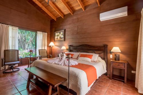福尔图纳宁静乡村酒店的一间带一张大床的卧室,位于带木墙的房间