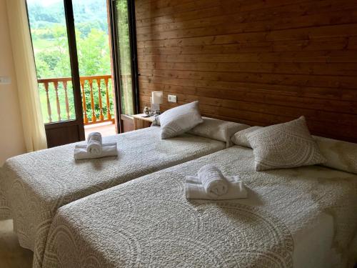 坎加斯-德奥尼斯Alojamiento Rural Cosorios的客房内的两张床和两条毛巾