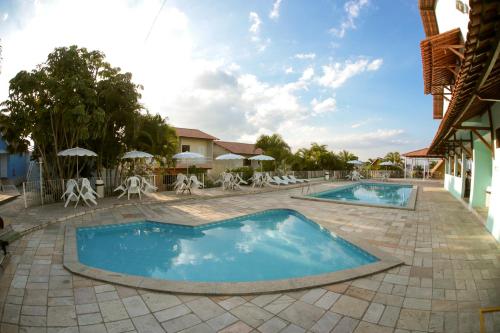 卡鲁阿鲁卡鲁阿鲁公园酒店的度假村的游泳池,配有椅子和遮阳伞