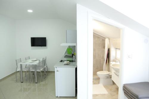 索科矿泉村Apartmani "ROSHU"的白色的浴室设有卫生间和桌子。
