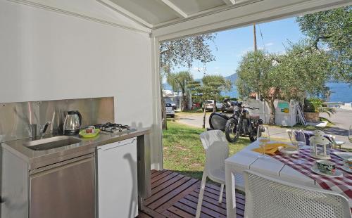 托里德尔贝纳科Camping Spiaggia D' Oro Torri的室外厨房配有桌子,享有水景