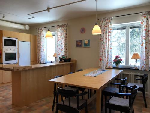 乌普萨拉哈加达林湾德拉旅馆的厨房以及带木桌和椅子的用餐室。