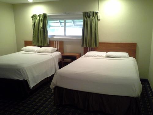 托纳万达托纳旺达经济旅馆的酒店客房设有两张床和窗户。